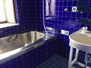 高松INARI - Vacation STAY 87349的蓝色瓷砖浴室设有浴缸和水槽