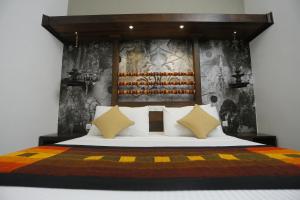 迪加纳塞伦迪布招牌度假村的一间卧室配有一张大床和木制床头板