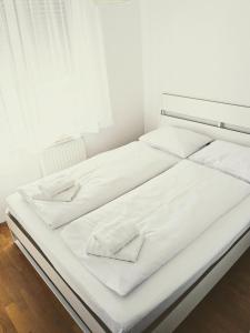 Velika MlakaDoMa-Lu apartment with free parking的白色的床,配有白色的床单和毛巾