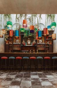 科特赖克Cobergher Hotel的餐厅内带红色凳子的酒吧