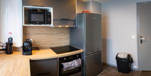 新城勒鲁瓦Résidence Hermès Paris Orly Aéroport的一间带柜台和冰箱的小厨房