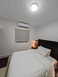 瓦迪穆萨埃及艳后酒店的卧室配有白色的床和电视。