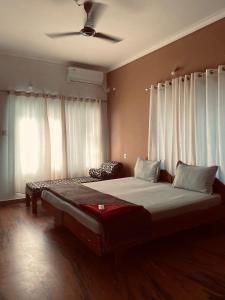 瓦尔卡拉hello beach view resorts的卧室配有一张带白色窗帘的大床