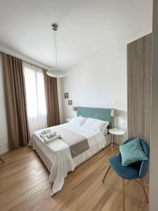 佛罗伦萨佛罗伦萨特来奥奇迪旅馆的一间卧室配有一张大床和一张蓝色椅子
