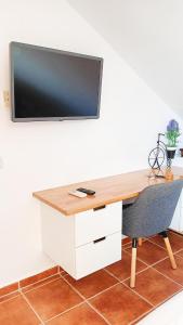 EsteponaSelwo Studio的一张桌子,墙上有一台电视,椅子