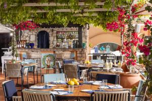 卡普里朋塔特拉嘉拉酒店的一间带桌椅的餐厅和一间酒吧