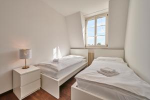 伯尔尼City Apartment Bern, perfect located and spacious的白色客房的两张床,设有窗户