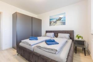 布拉迪斯拉发BNB Slovakia Ovocné sady Airport Apartment的卧室内的两张床,配有蓝色毛巾