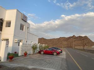 IbrāTafadal的停在路边建筑物旁边的红色汽车