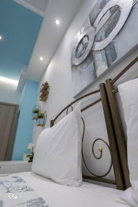 雅典'The Aqua'House Project In Athens的卧室配有一张带白色枕头和板子的床铺。