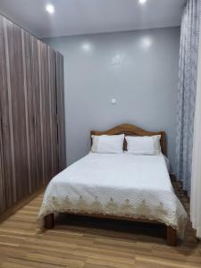 基加利ASMERA GUEST HOUSE的一间卧室配有一张带白色床单的大床