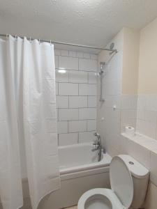 伦敦Wembley house的白色的浴室设有卫生间和浴缸。