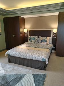 瑞维尼亚克Suite Deluxe vue sur Golf的一间卧室配有一张大床和两个枕头