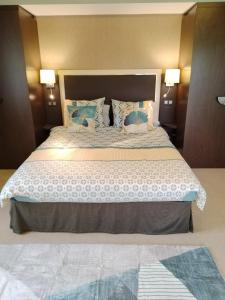 瑞维尼亚克Suite Deluxe vue sur Golf的一间卧室配有一张带蓝色枕头的大床