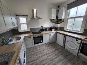 诺丁汉Nottingham Forest Rd, Short Stays的厨房配有白色橱柜、水槽和洗碗机。