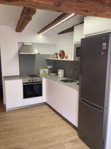 阿尔巴拉辛Casa Román的厨房配有白色橱柜和黑色冰箱。