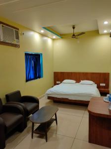 德奥加尔Hotel Bharati的一间卧室配有一张床、一张沙发和一张桌子
