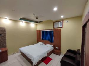德奥加尔Hotel Bharati的卧室配有白色的床和椅子