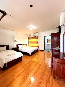 万荣Vang Vieng Global Hostel的一间卧室设有两张床,铺有木地板
