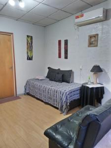 门多萨Departamentos Avenida San Martin的一间卧室配有一张床、一张桌子和一张沙发