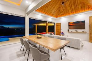 苏梅岛Villa Nirvana - Wonderful Sea View的一间带木桌和椅子的用餐室