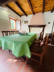 GuigliaCasa del Viandante Borgo dei Sassi di Roccamalatina的一间带绿色桌椅的用餐室