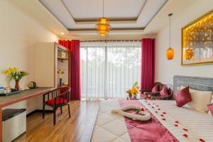 Phumĭ Ta PhŭlAngkor Rithy Residences的客房设有一张床、一张书桌和一间厨房