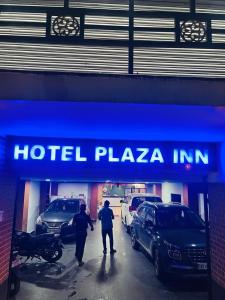 古瓦哈提PuHoR Hotel Plaza Inn的两个人站在旅馆广场前