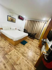 古瓦哈提PuHoR Hotel Plaza Inn的一间卧室配有一张床和一台电视