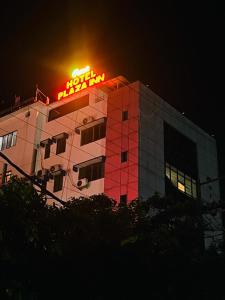 古瓦哈提PuHoR Hotel Plaza Inn的上面有 ⁇ 虹灯标志的建筑