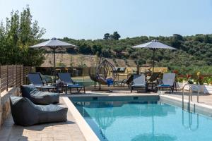 干尼亚Sirena Villa的游泳池旁设有躺椅和遮阳伞