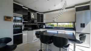 艾瑟尔河畔卡佩勒Big 5-bedroom house in Capelle aan den IJssel的厨房配有黑白电器和黑凳子
