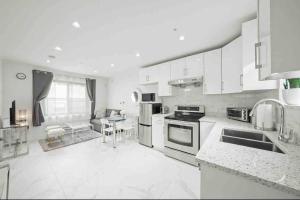 温哥华Entire NEW Cozy and Modern 2-storey HOUSE的厨房配有白色橱柜和桌子