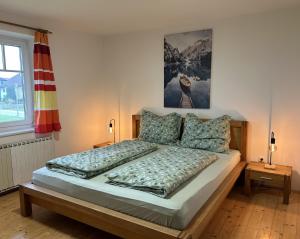 阿特尔高地区圣格奥尔根Traumhaft große Ferienwohnung nähe Attersee的一间卧室配有一张带2个床头柜的大床