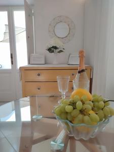 阿纳卡普里L'Archetto romantic suite in the center of Anacapri的桌上放一碗葡萄和一瓶葡萄酒