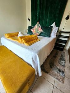 乌姆塔塔Adante Lodge & Conferencing的一间卧室配有一张带黄色毯子的大床