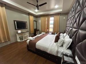 斯利那加Fair Mount的一间卧室配有一张大床和一台平面电视