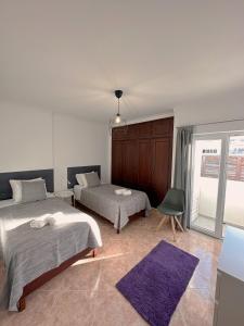 阿尔沃尔Alvor Apartment的一间卧室配有两张床和紫色地毯。
