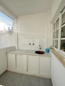 阿尔沃尔Alvor Apartment的白色的厨房设有水槽和窗户