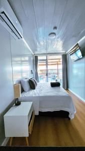 CareneroSuites Bocas del Toro的一间设有白色床的卧室,位于带窗户的房间内