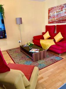 维也纳Luxurious city apartment incl garage and terrace的客厅配有红色的沙发和桌子