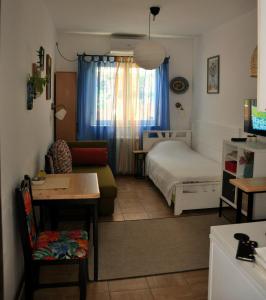 ObrenovacStudio5, sa parkingom, centar Obrenovca的一间卧室配有一张床、一张沙发和一张桌子