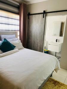 哈博罗内Central Gabs Oasis: 2BR-Retreat的卧室配有白色的床和水槽