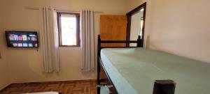 伊瓜苏Casa perto das Cataratas Seu lar para quatro的一间卧室设有一张床、一个窗口和一台电视