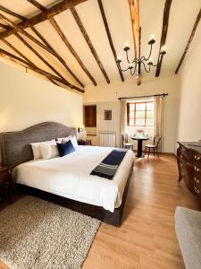 库斯科帕拉西奥曼科阿纳奈酒店的一间大卧室,配有一张大床和一张桌子