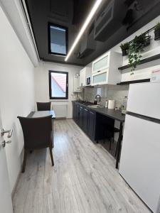 Popeşti-LeordeniPerla Home - Studio 9的厨房配有桌椅和冰箱。