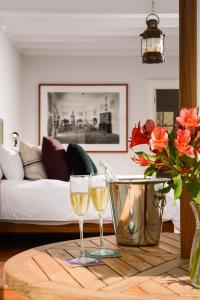 利马Villa Barranco by Ananay Hotels的客厅的木桌旁放着两杯葡萄酒