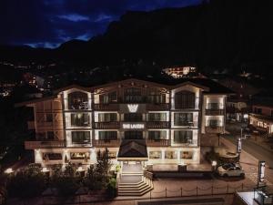 塞尔瓦迪加尔代纳山谷The Laurin Small & Charming的夜晚的酒店,以山为背景