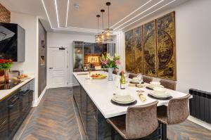 布莱克浦Swish Luxury Holiday Apartments的厨房配有白色的大桌子和椅子