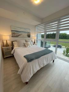 Innisfil2 bedroom 2 bath Aquarius, Friday Harbour, Innisfil, Barrie的一间卧室设有一张大床和一个大窗户